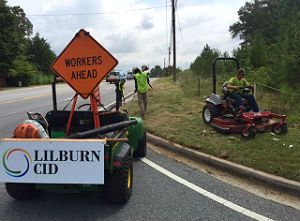Workers cutting grass in right-of-way
